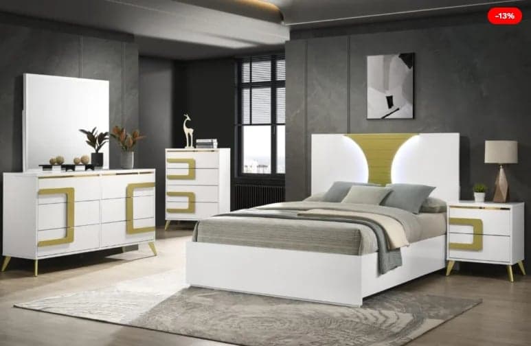 Modern bedroom set with white and gold furniture including bed, dresser, nightstands, and mirror in contemporary home interior