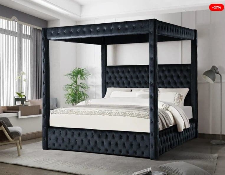 Black upholstered canopy bed with white bedding in modern bedroom with plants and seating area