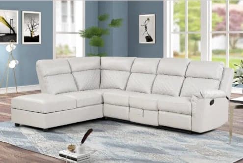 Cream-colored sectional sofa with recliners in a modern living room with blue-gray walls and large windows.