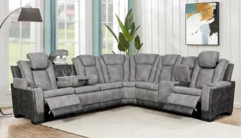 Gray power reclining sectional sofa in modern living room with plants, lamp, and large windows