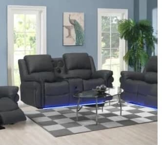 Cesar Living Room furniture set featuring dark gray recliners with center console and glass table on blue-lit checkered floor