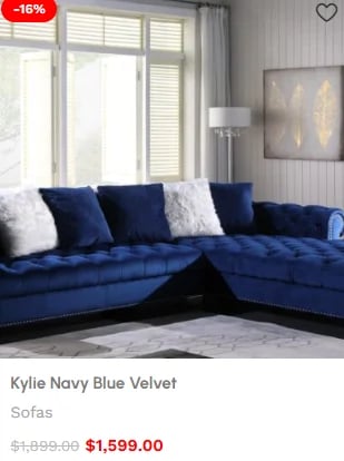 Navy blue velvet L-shaped sectional sofa with white and blue pillows in a bright living room with large windows
